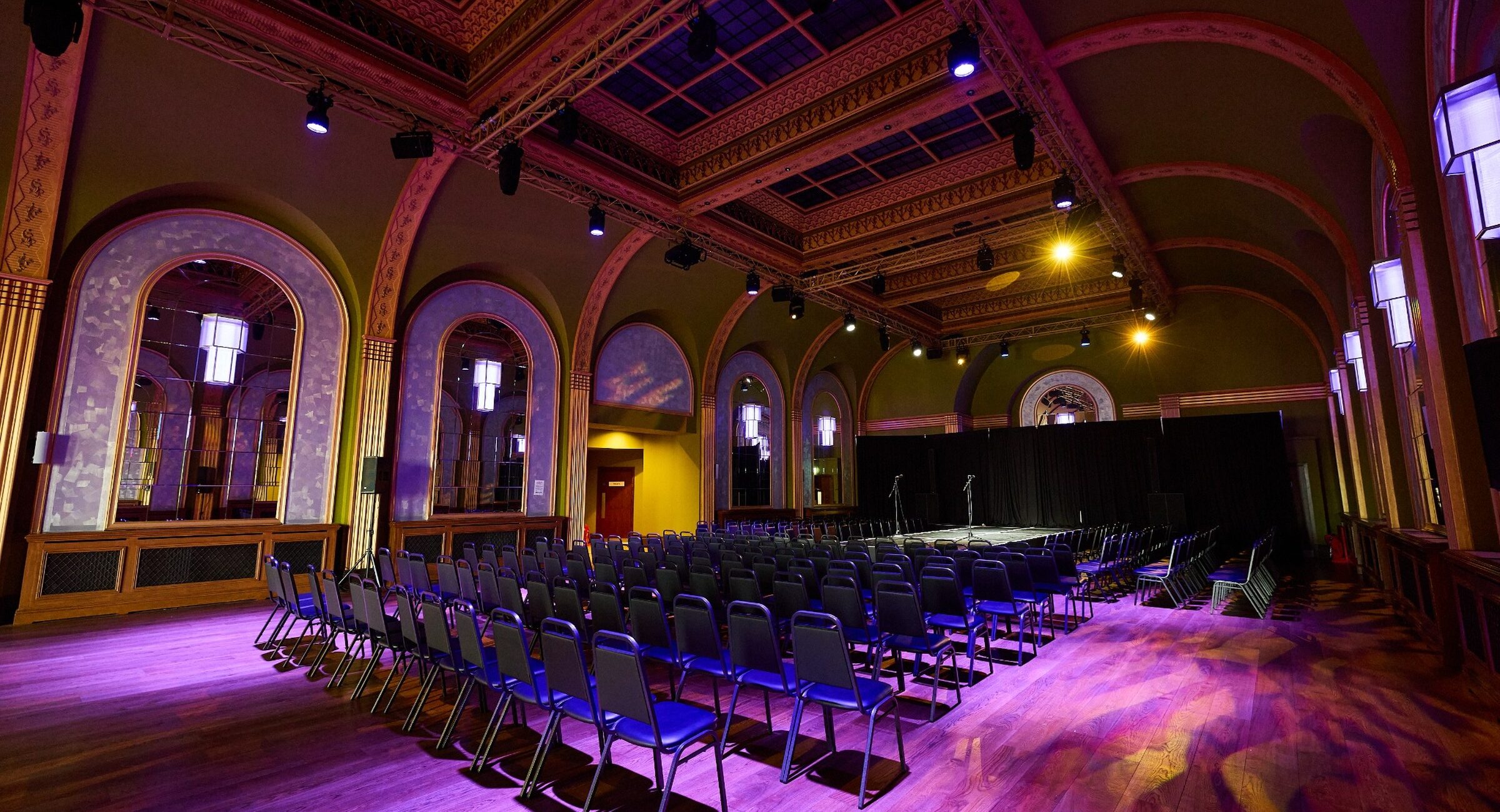 A large foyer space with bright spotlights highlighting rows of seating
