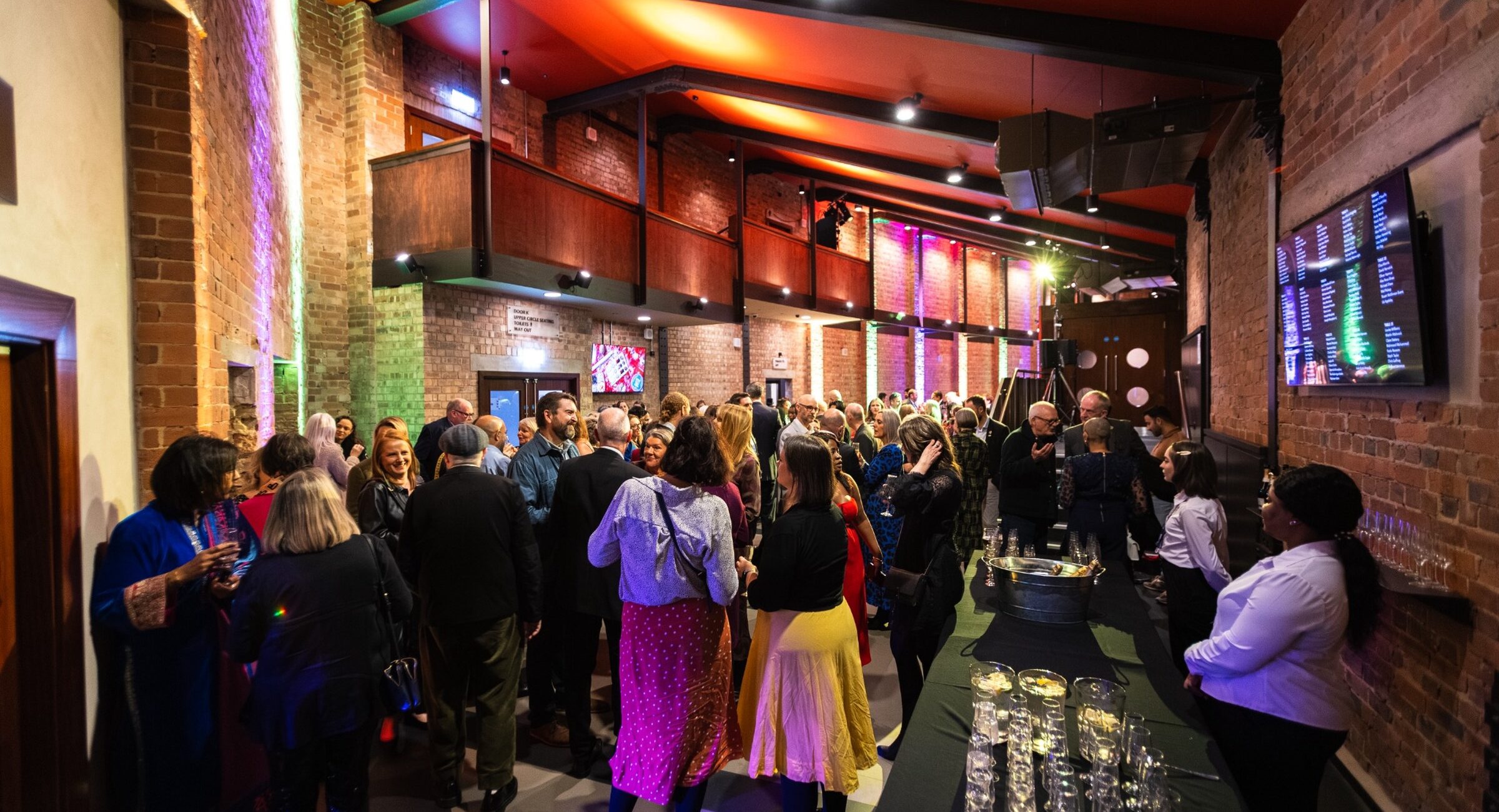 Inside a smaller foyer space with people getting interval drinks
